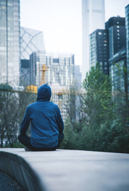 istock Young man sitting and looking at cityscape 947314102