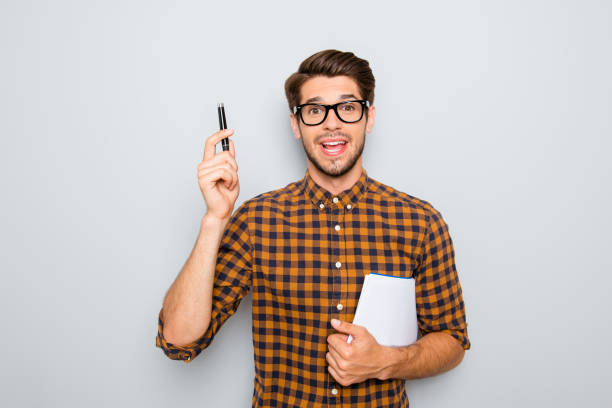 istock Smart  student in glasses  with great idea holding notebook and pen 947314630