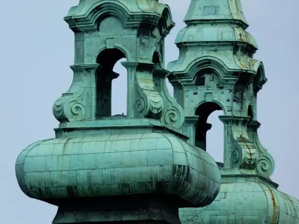 closeup detail of green copper church towers at church bell level