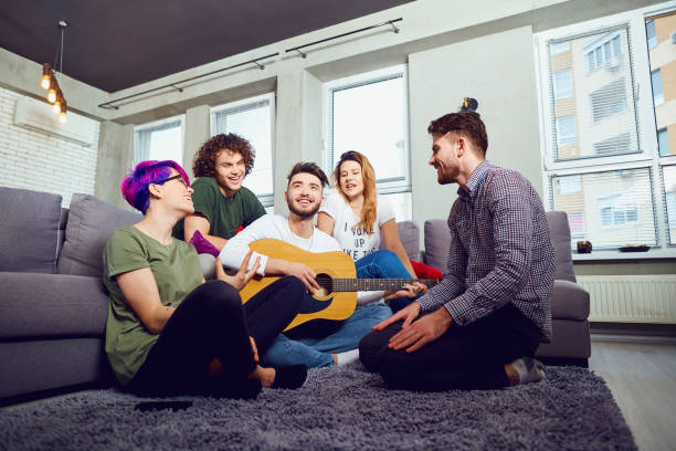 istock Friends playing the guitar, sing fun indoors 947315400
