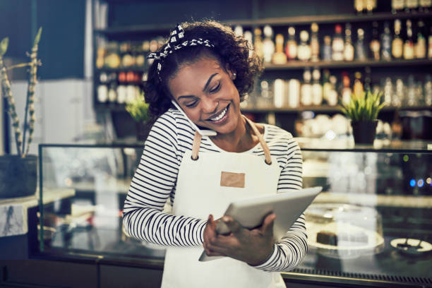 istock Smiling young African entrepreneur taking reservations in her cafe 947315658