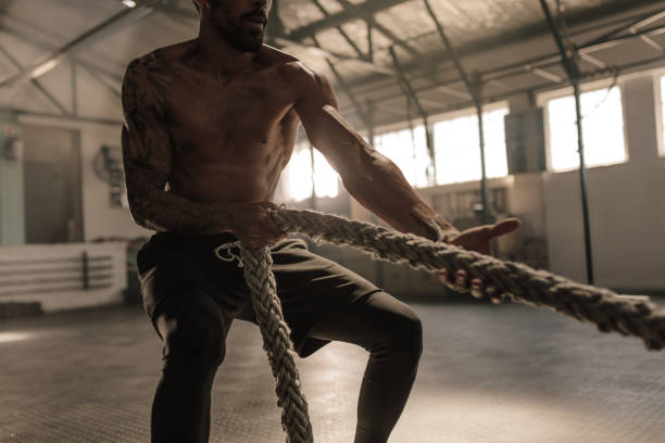 istock Athlete doing exercises with rope at gym 947316730