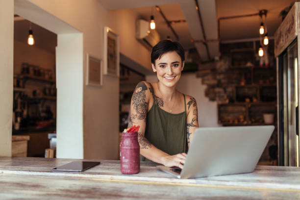 femme travaillant sur un ordinateur portable - tatouage femme photos et images de collection