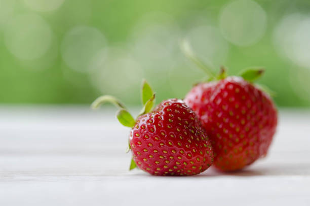 istock two strawberries on a wooden table 947320416