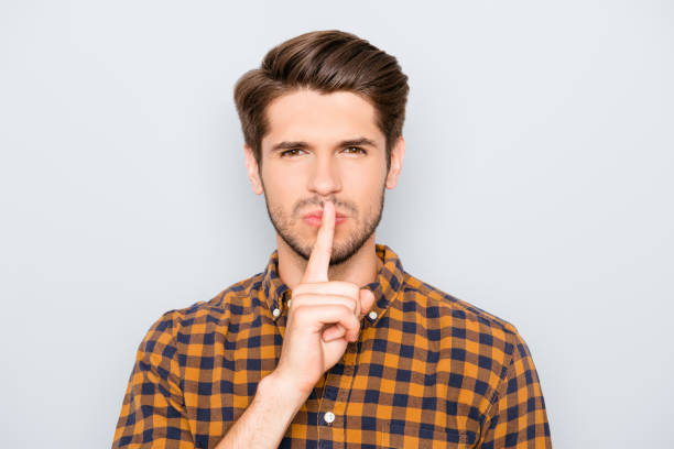 istock Young handsome guy in checkered shirt showing silent gesture 947322800