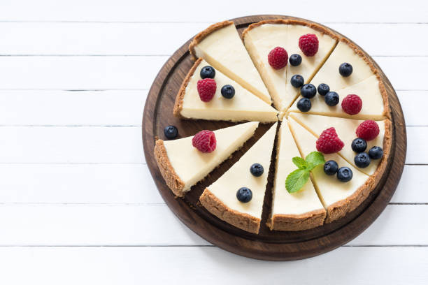 cheesecake con bacche estive tagliate a pezzi su sfondo bianco - dessert fruit torte red foto e immagini stock
