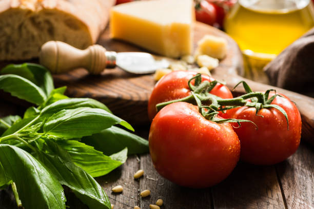 fondo de comida italiana con tomates en la vid, albahaca, aceite de oliva, queso parmesano y pan ciabatta pan - tomatoes on vine fotografías e imágenes de stock