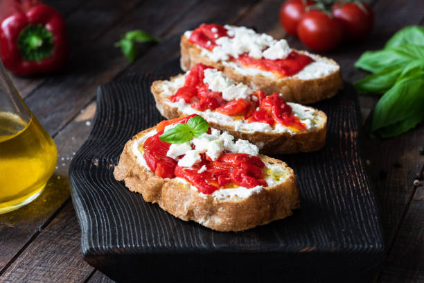 bruschetta with roasted pepper and goat cheese - bruschetta cutting board italy olive oil imagens e fotografias de stock