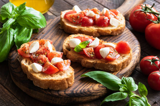 istock Bruschetta with tomato, basil and mozzarella cheese on wooden board 947324372
