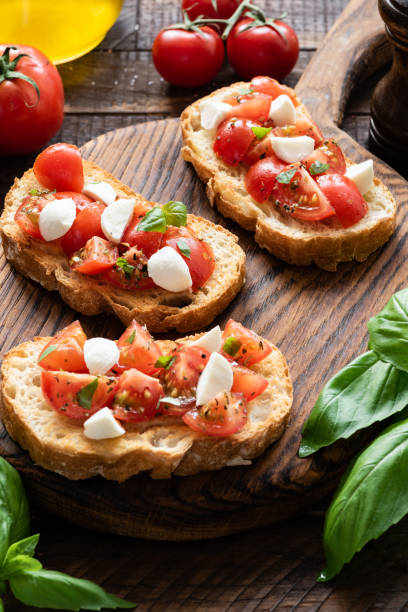 istock Tomato and mozzarella bruschetta on a wooden board 947324404