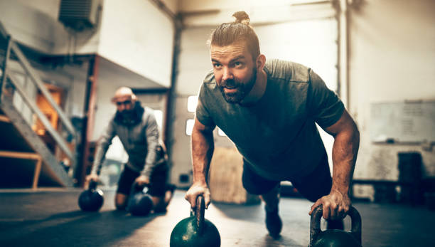 istock Fit man doing pushups with weights on a gym floor 947331706