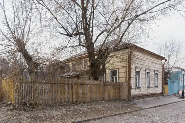 Wooden house of the nineteen century and fence in a cloudy day