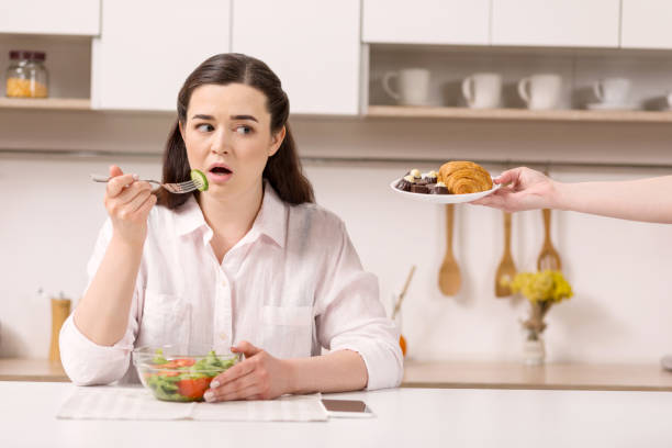 istock Musing nice woman tempting by croissant 947335276