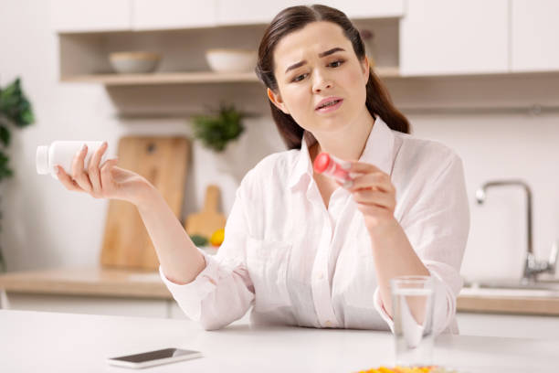 istock Disquieting restless woman examining medications 947340538