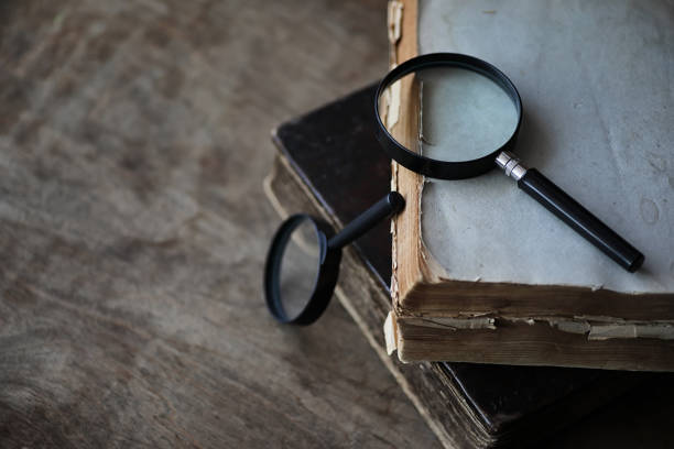 istock Old books on a wooden table and magnifier 947340870