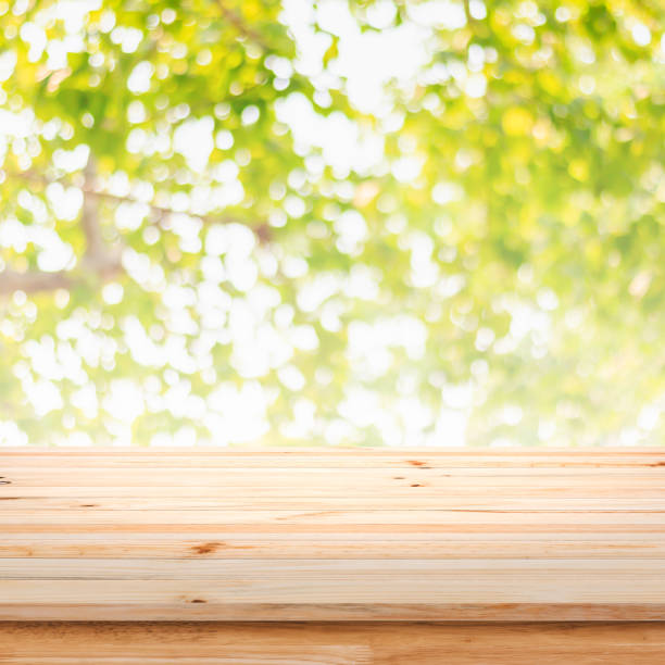 istock Wooden table on green bokeh background. 947343358