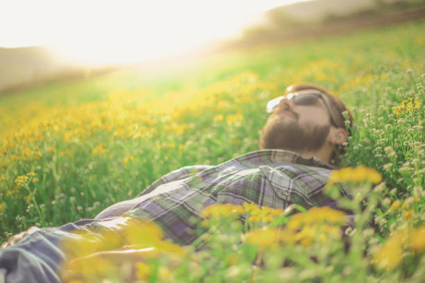 istock A man in a shirt with sunglasses lying in the grass 947343550