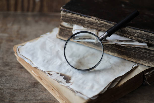 istock Old books on a wooden table and magnifier 947343586