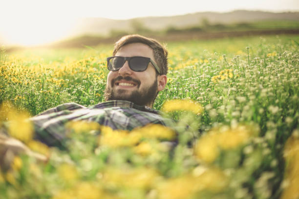 istock Man lying on magical field  and beautiful nature 947343624