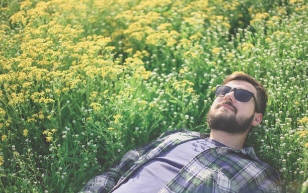 istock A man in a shirt with sunglasses lying in the grass 947343672