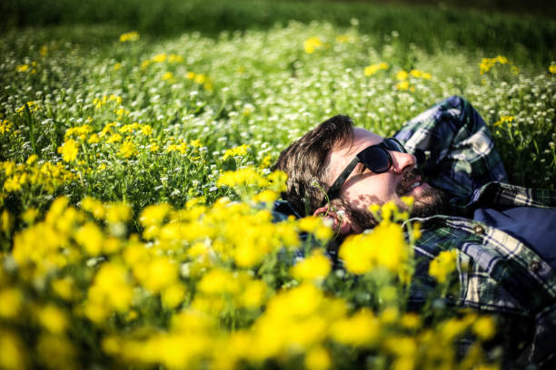 istock A man in a shirt with sunglasses lying in the grass 947343764