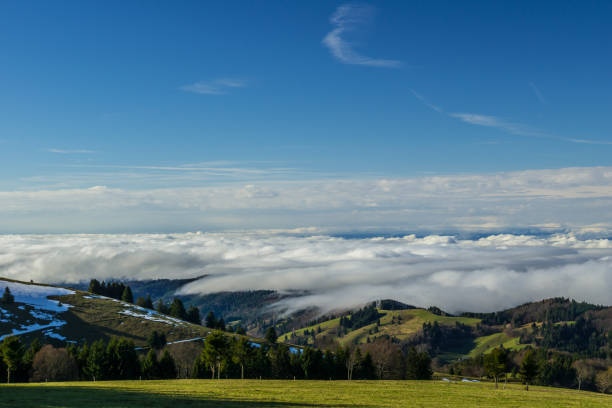 Germany, Above the clouds on a mountain on a sunny day with snow
