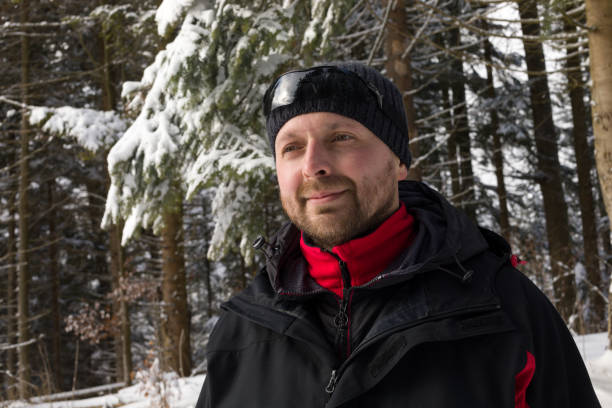 istock A cheerful man is standing in the winter forest 947348692