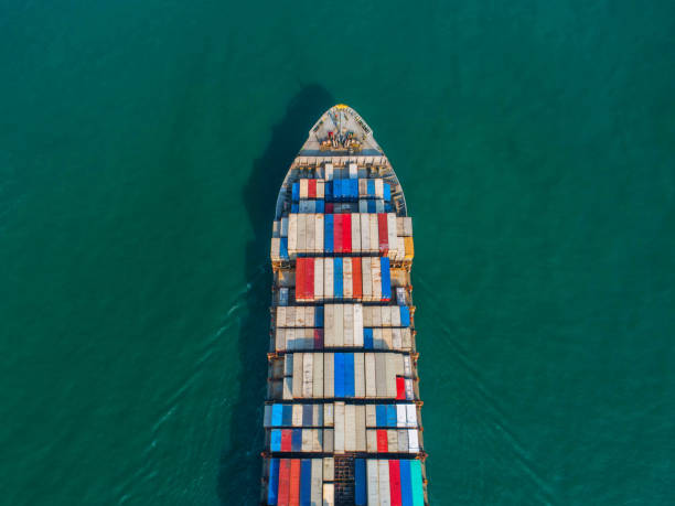 istock Container ship in export and import business and logistics. Shipping cargo to harbor by crane. Water transport International. Aerial view and top view. 947354384
