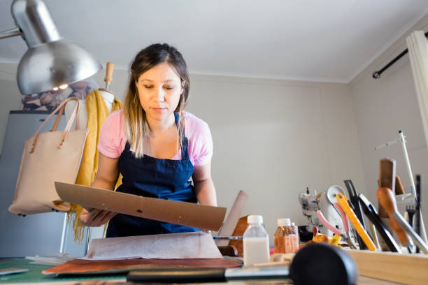 istock Young woman artisan working with leather 947358034