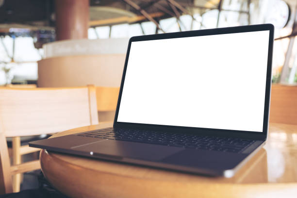 istock Mockup image of computer laptop with blank white desktop screen on wooden table in cafe 947364870