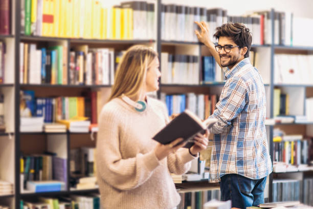 istock Happy student couple with books in library 947369652