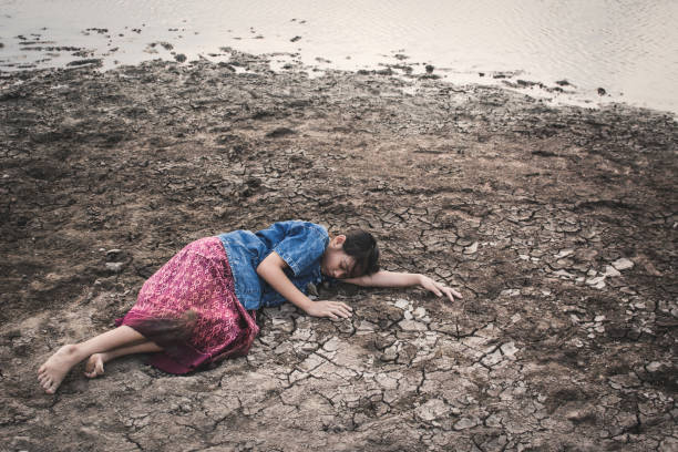 istock High Angle View Of Girl Lying On Arid Field 947372798