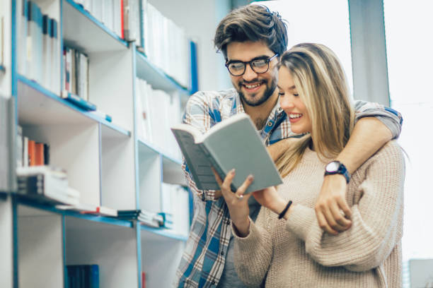 istock Happy student couple with books in library 947373642