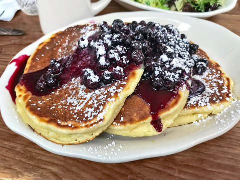 Pancakes with blueberry sauce on a cafe table