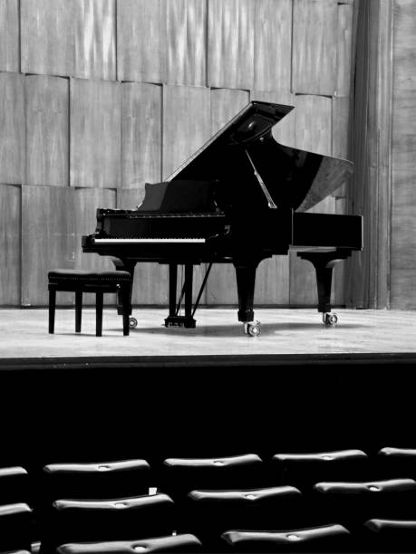 istock Black concert piano is standing on a wooden stage 947382242