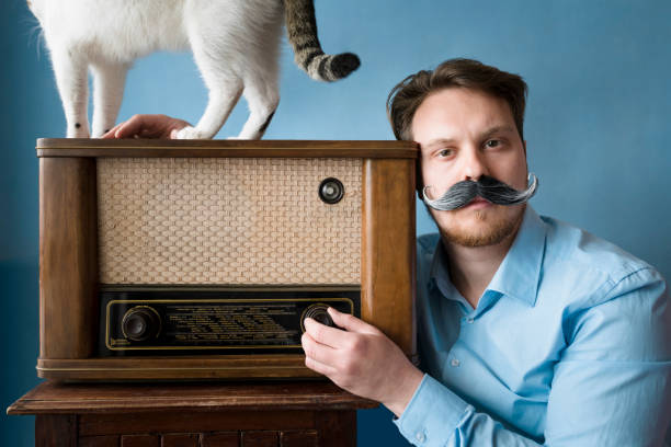 istock Handsome hipster spending time with cat & retro-style radio 947382670