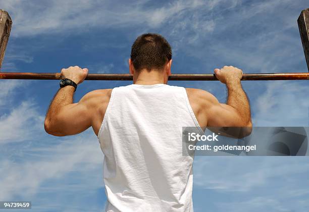 A Man Doing Pull Ups In Front Of A Blue Sky Stock Photo - Download Image Now - Achievement, Adult, Adults Only