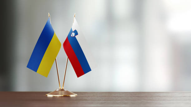 istock Ukrainian And Slovenian Flag Pair On A Desk Over Defocused Background 947397018