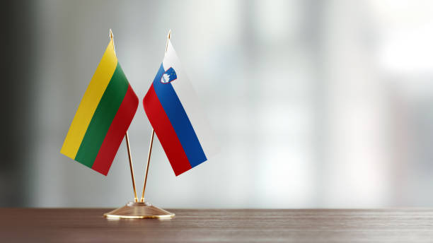istock Lithuanian And Slovenian Flag Pair On A Desk Over Defocused Background 947397920