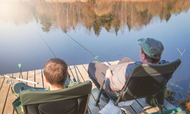 istock Two men fishing rod fish. 947397956