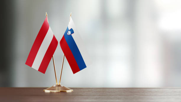 istock Austrian And Slovenian Flag Pair On A Desk Over Defocused Background 947400342