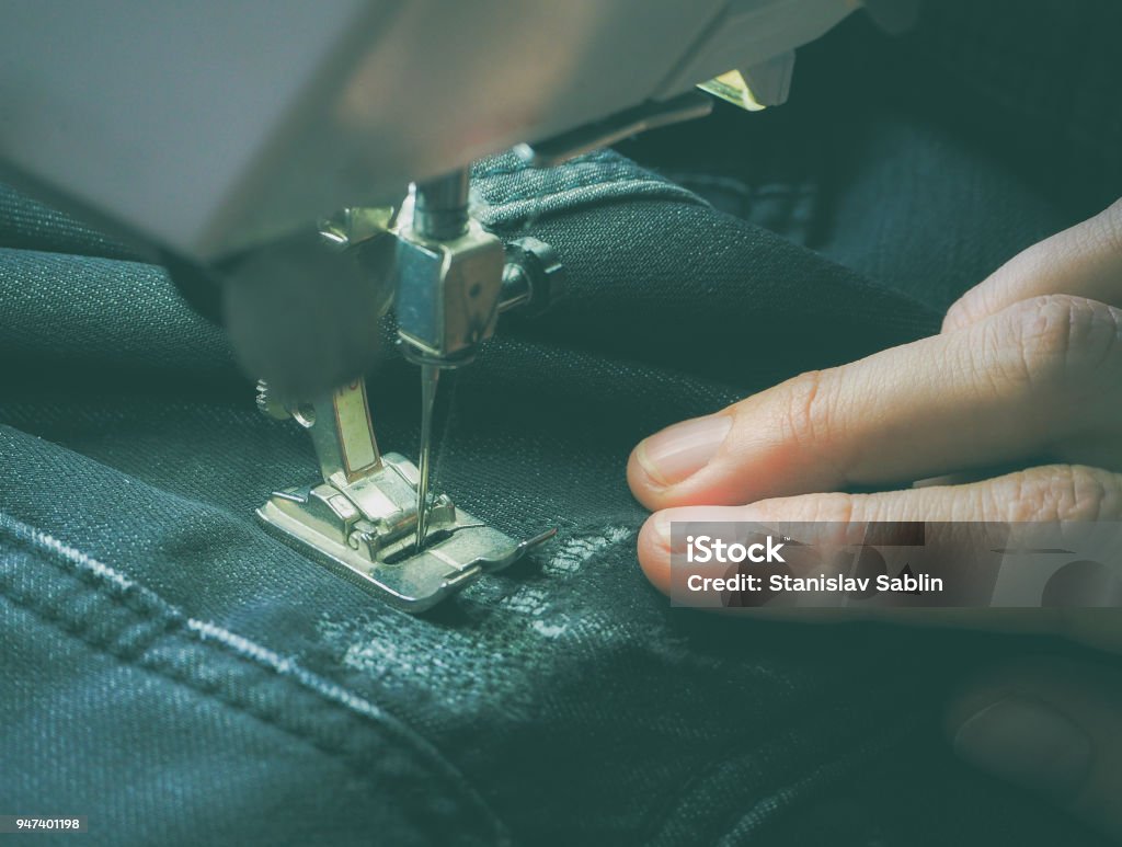 Plano de processo de costura na máquina de costura. O pé calcador e a agulha da máquina de costura durante a operação. - Foto de stock de Agulha royalty-free