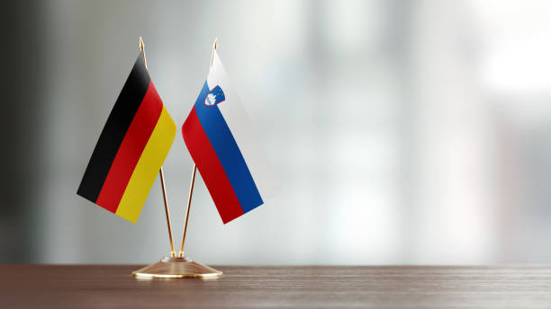 istock German And Slovenian Flag Pair On A Desk Over Defocused Background 947402560