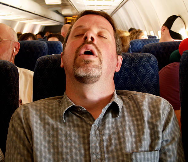 Tiring Flight Man sleeping on a long flight with his mouth wide open; a great candid shot with lots of stock potential! Copy space.  narcolepsy stock pictures, royalty-free photos & images