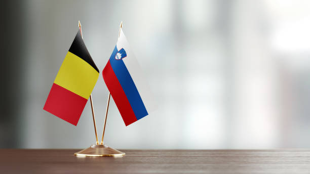 istock Belgian And Slovenian Flag Pair On A Desk Over Defocused Background 947408214
