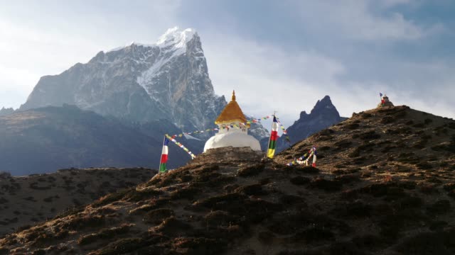 Steadicam shot of stupa with prayer flags on track to the base camp of Everest in the Himalayas, Nepal