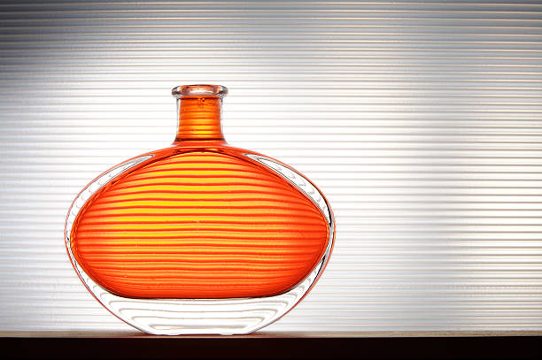 A close up shot of orange flowers in ice in a white vase. The porcelain vase has fluted surface. The vase with a bunch is isolated against the black background. Bright reminding of season.