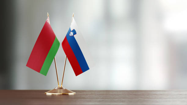 istock Belarus And Slovenian Flag Pair On A Desk Over Defocused Background 947414378