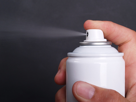 Macro of generic aerosol can spraying; copy space