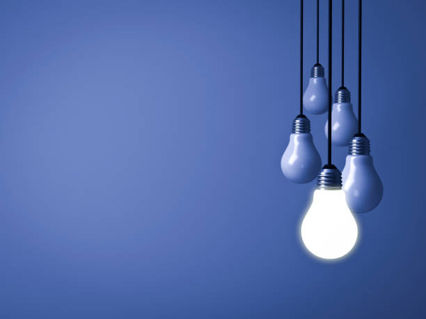 istock One hanging light bulb glowing on dark blue background with unlit light bulbs . 3D rendering 947417980